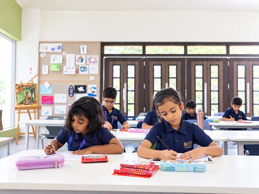Primary students drawing in a bright UWA classroom