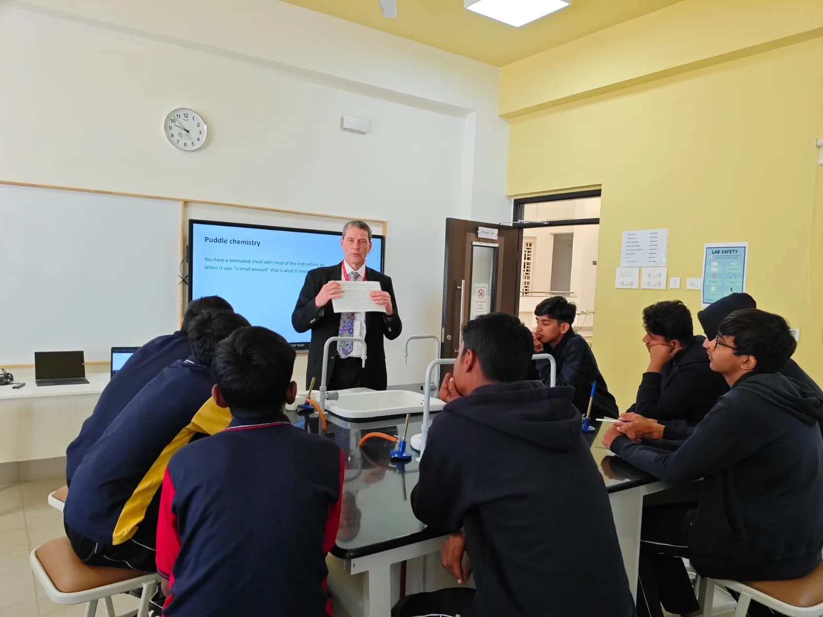 A visiting faculty member presenting to students in a science lab