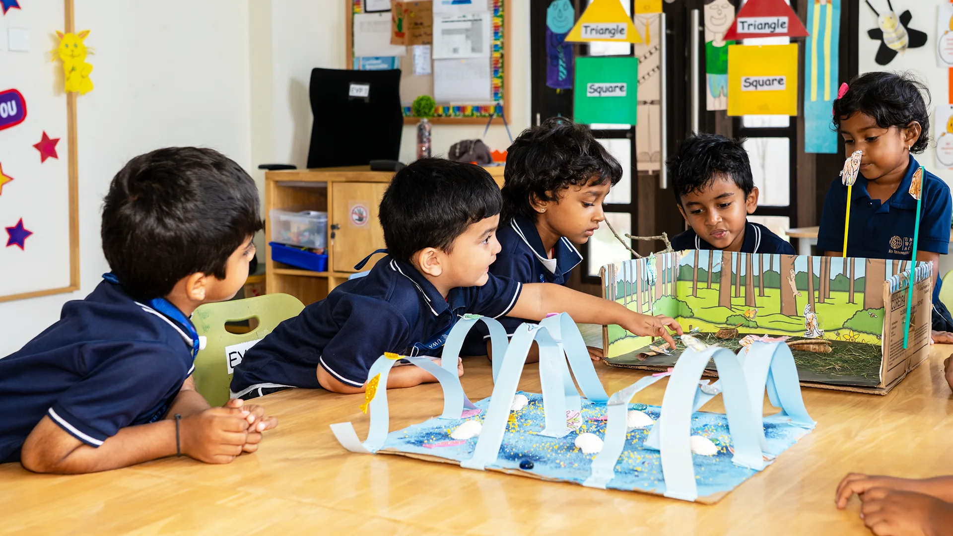 Young students at United World Academy working together on a hands-on classroom project